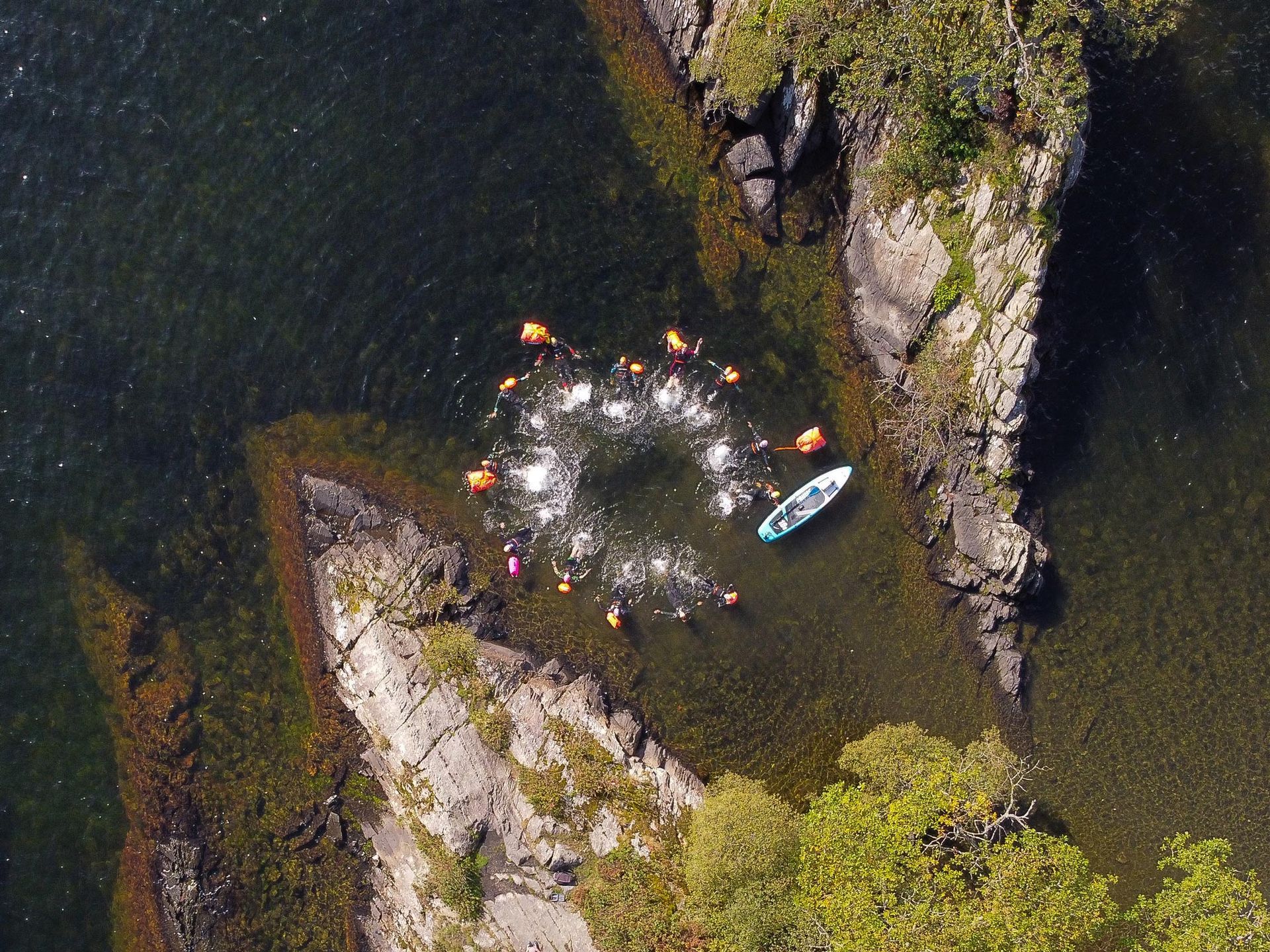 An aerial view of a group of people in kayaks in the water.