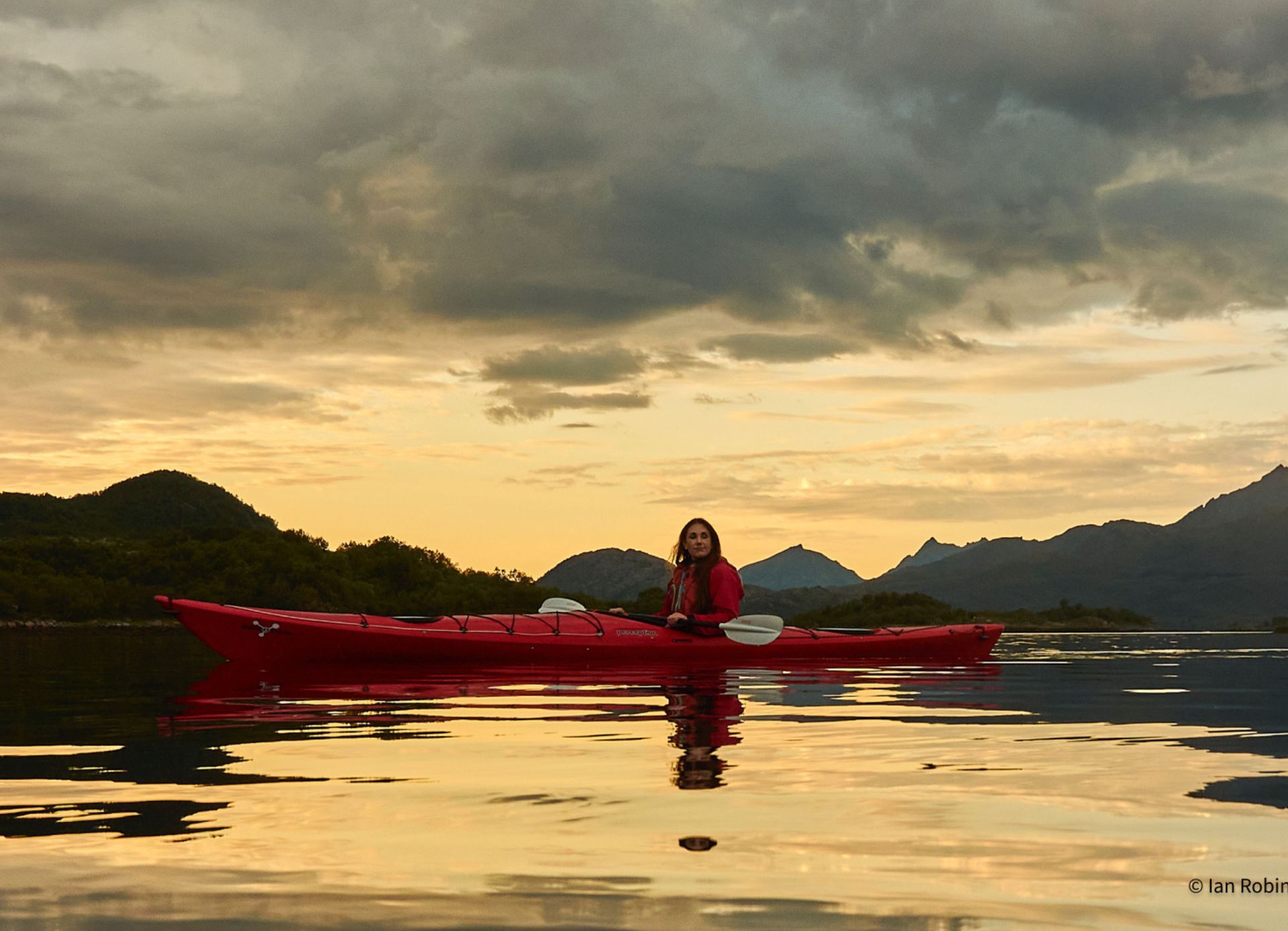 Guest kayaking on the fjord in evening light