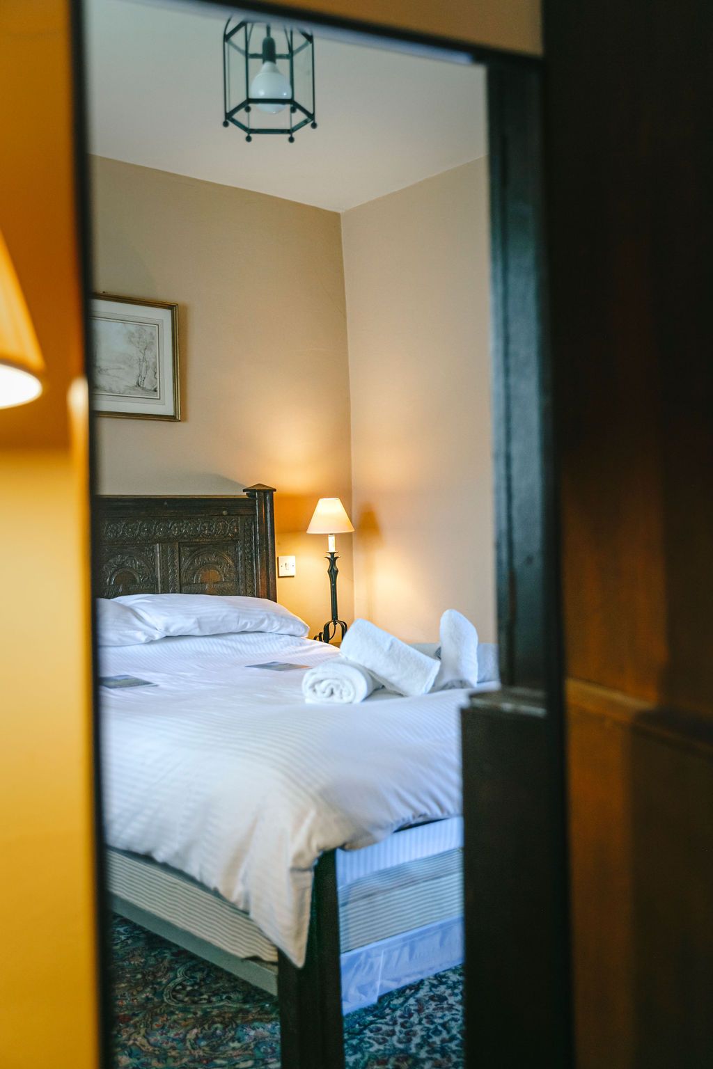 A bright, bedroom with king bed, cushions and bed side tables.