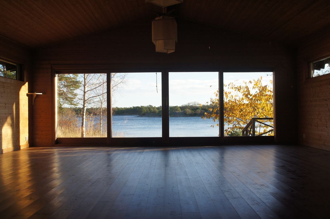 Yoga studio with mats, pillows, towels, and blocks, ready for a class. Bright, sunlit room, wooden floor.