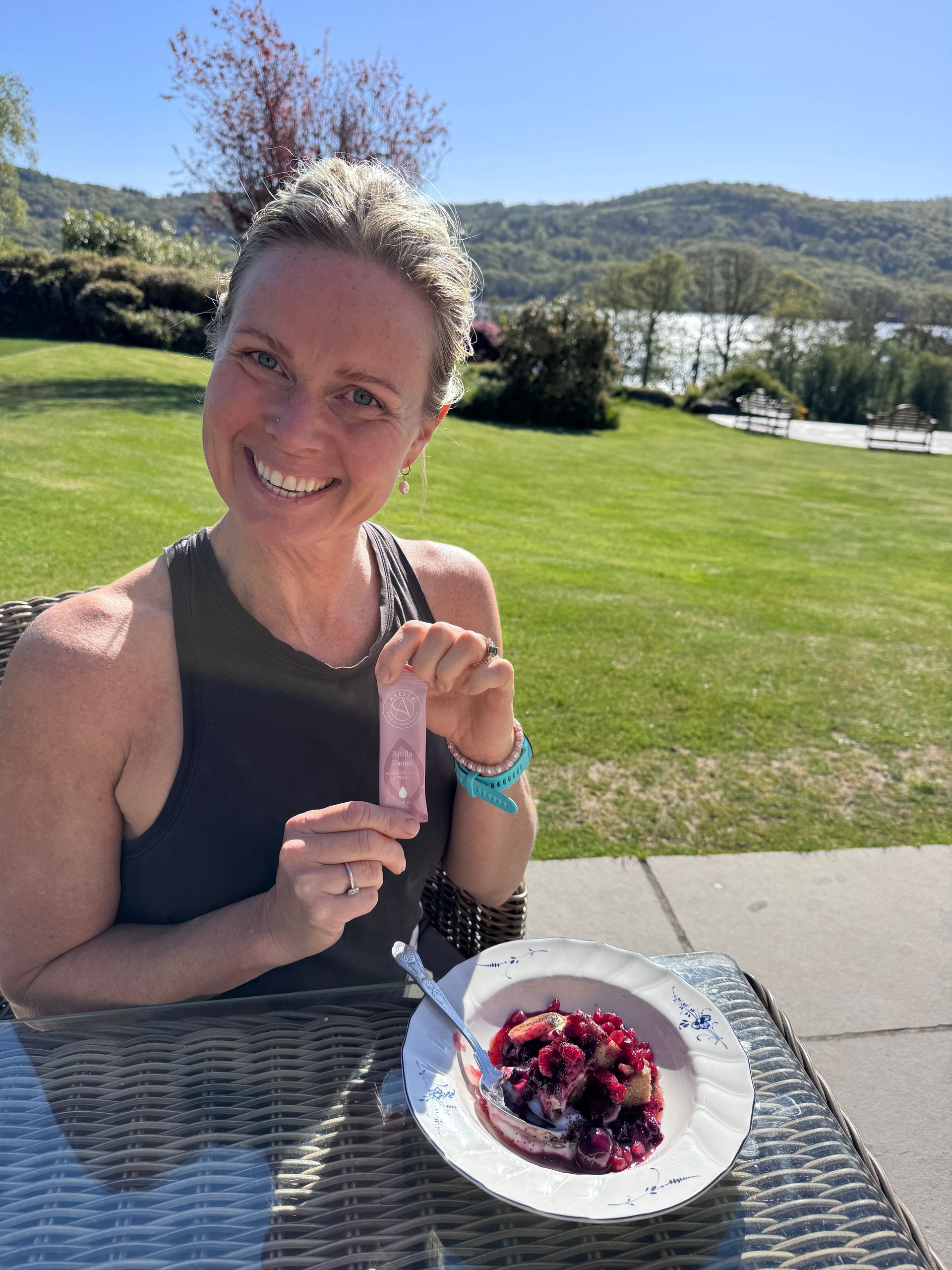 a woman holding collagen, eating breakfast in the sun, lake district