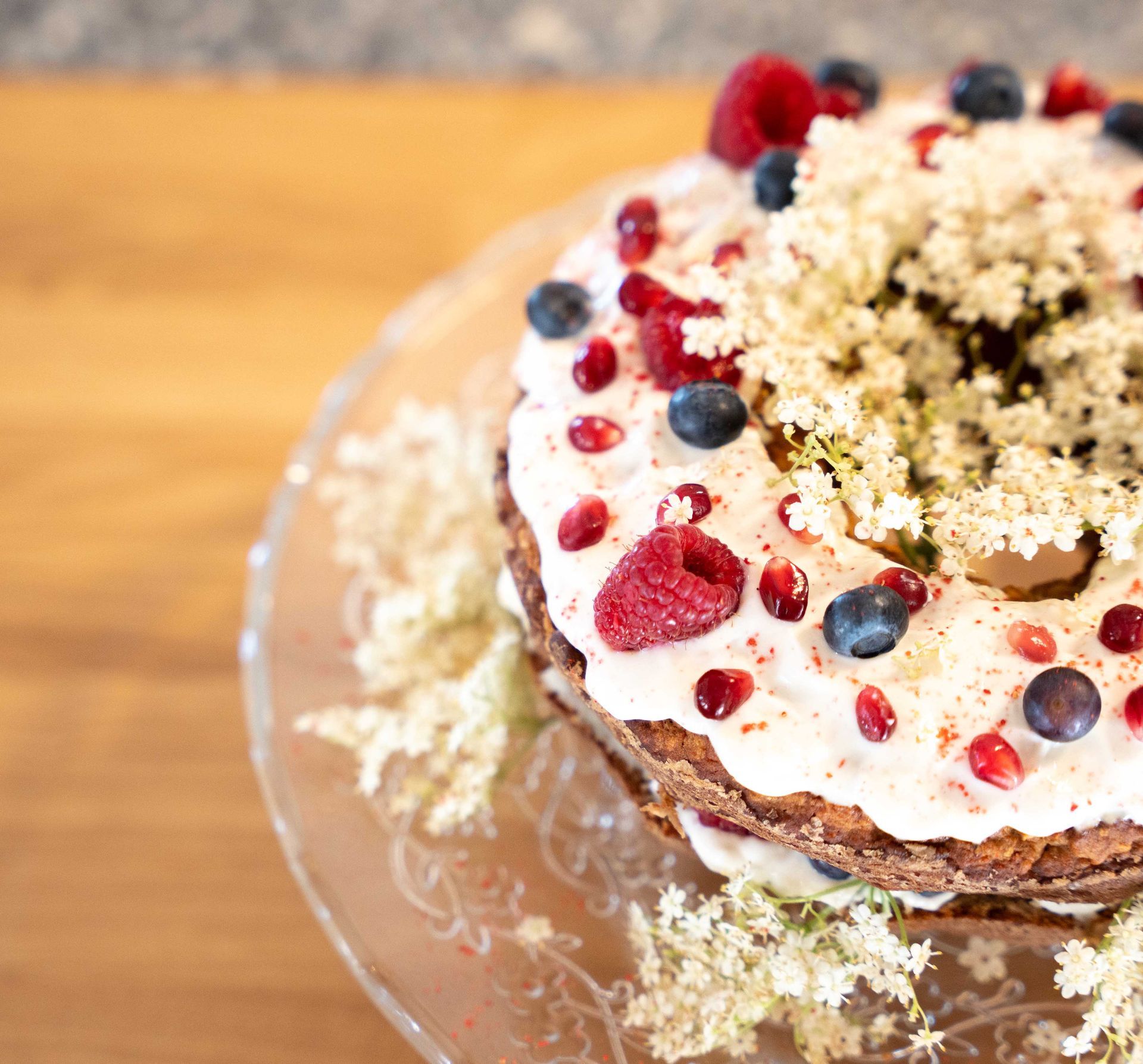 A cake with raspberries and blueberries on top of it