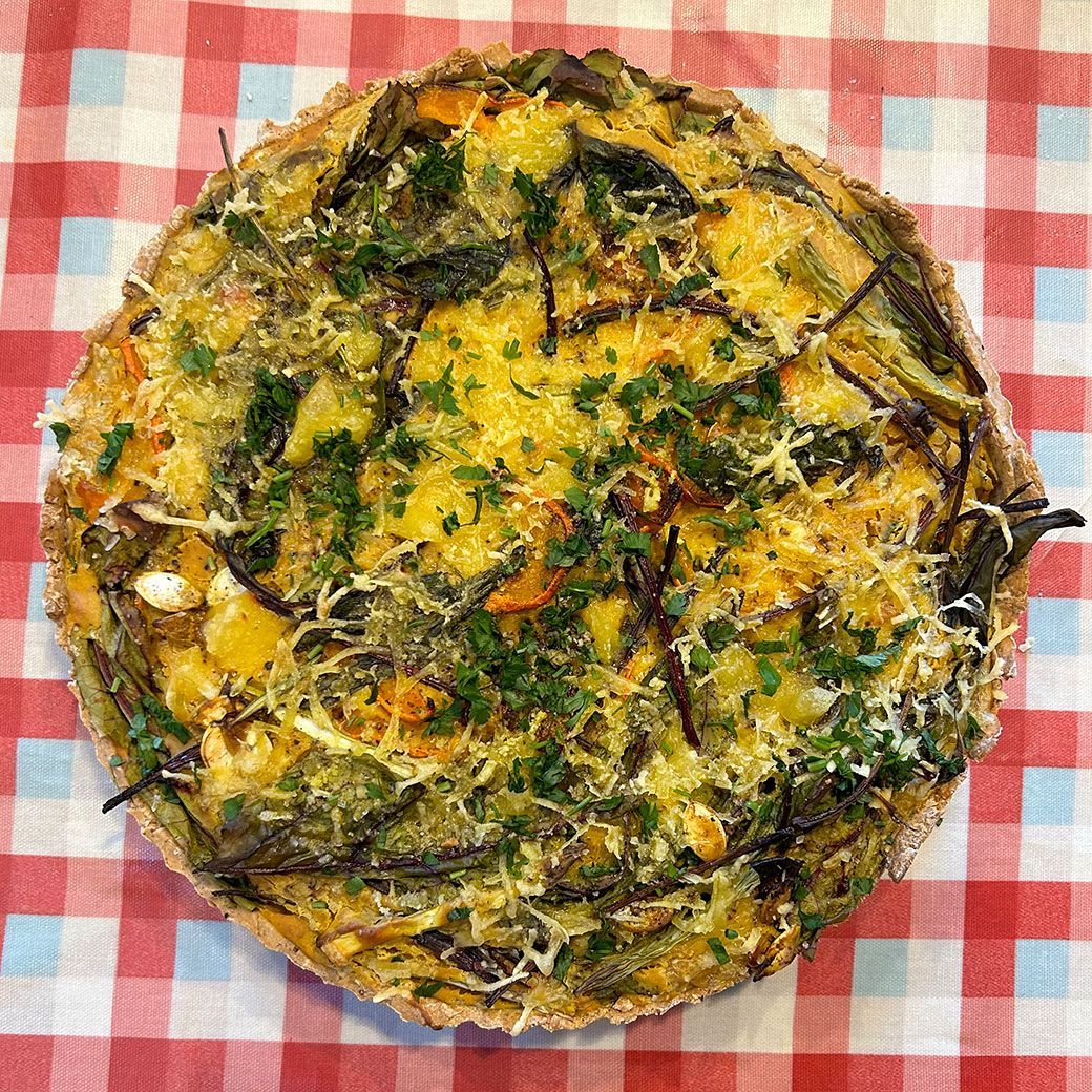 Vegetable quiche on a red and white checkered tablecloth.