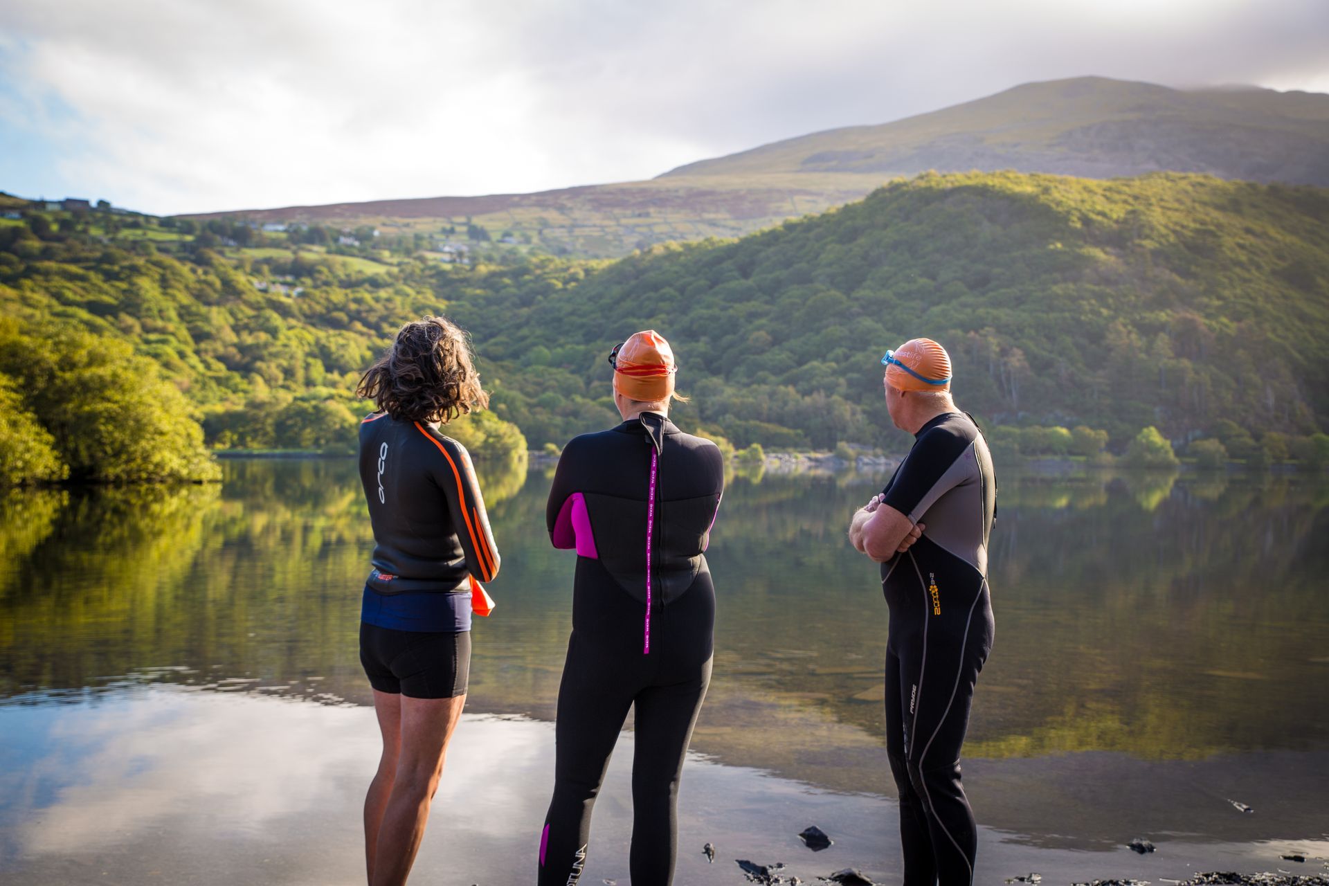 Three people standing looking out to a lake