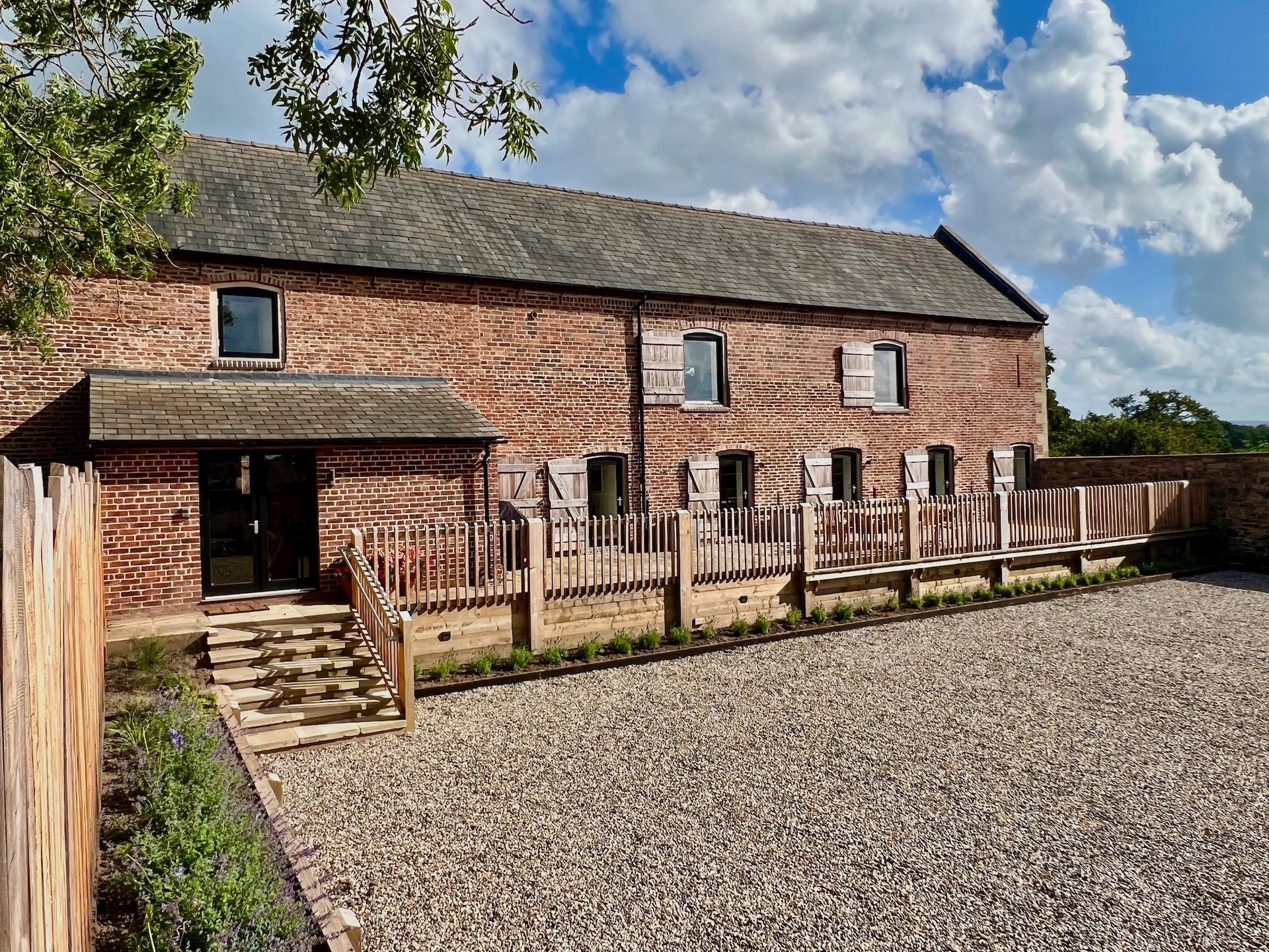 front of a barn with terrace and gravel driveway