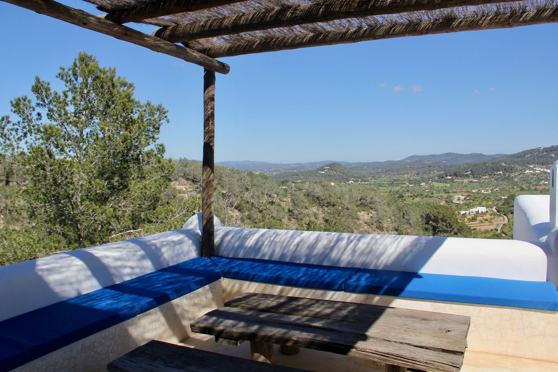 Shaded terrace with blue cushions looking across the Sant Agustí valley, Ibiza