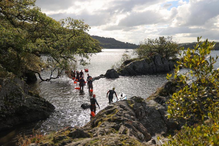 A group of people are walking out of a lake.