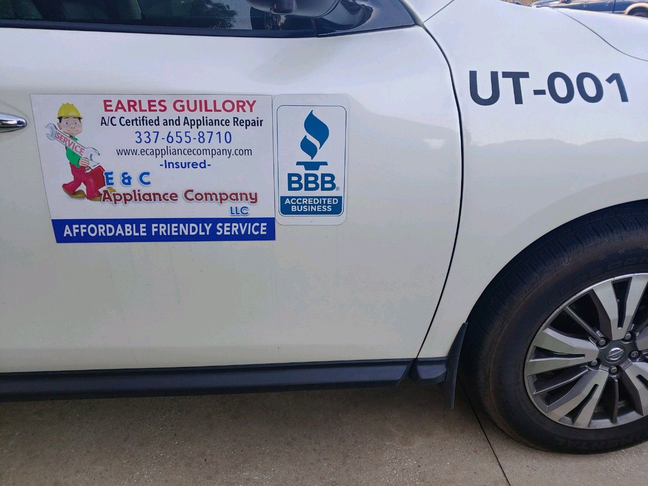 White pickup truck with company decals and UT-001 on the side door