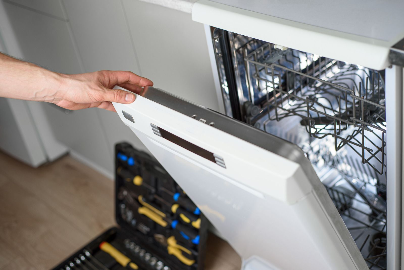 Hand lifting open a white server rack door in a data center, revealing wiring and equipment inside