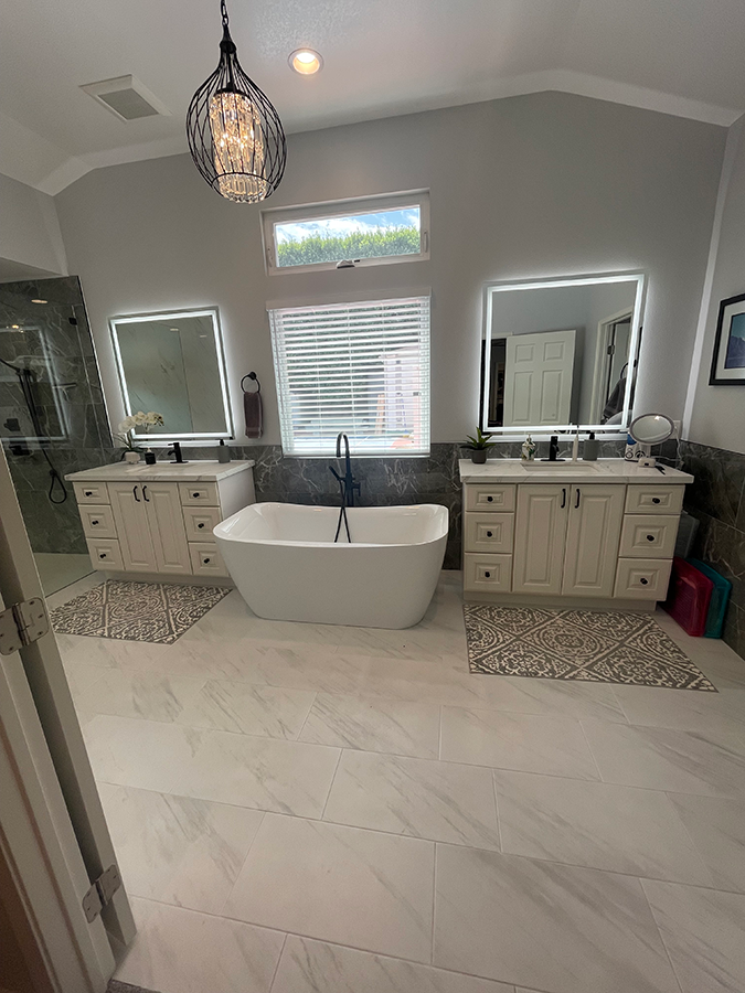 Luxurious modern bathroom with dual vanities, bathtub, large mirrors, and light fixtures.