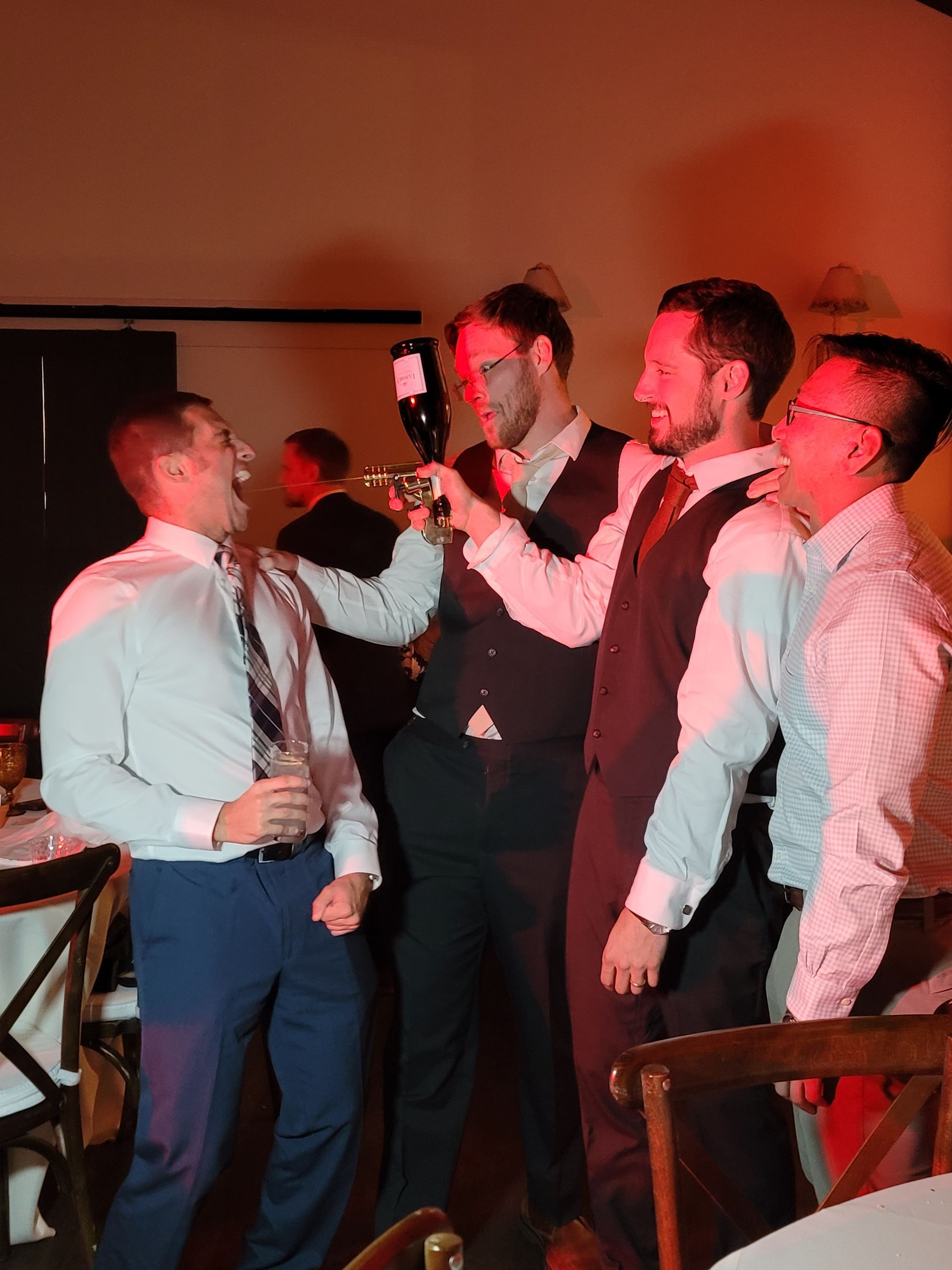 groom and groomsmen shooting champagne gun