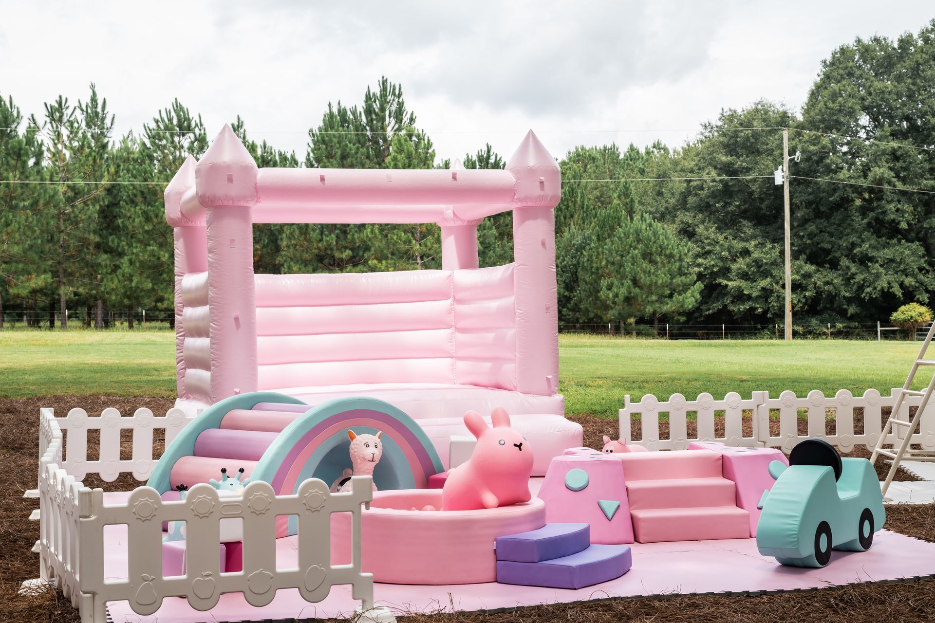 pastel bounce castle and outdoor toys for party