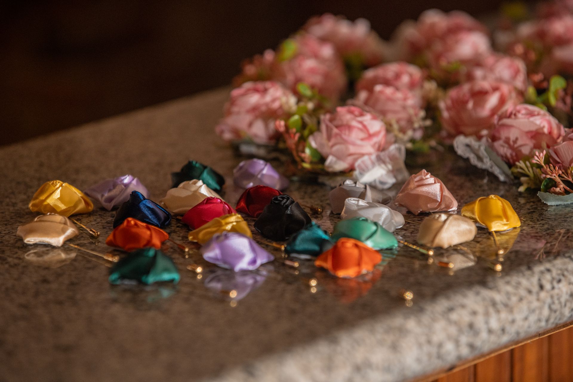 Colorful wrapped candies and pink roses arranged on a granite countertop