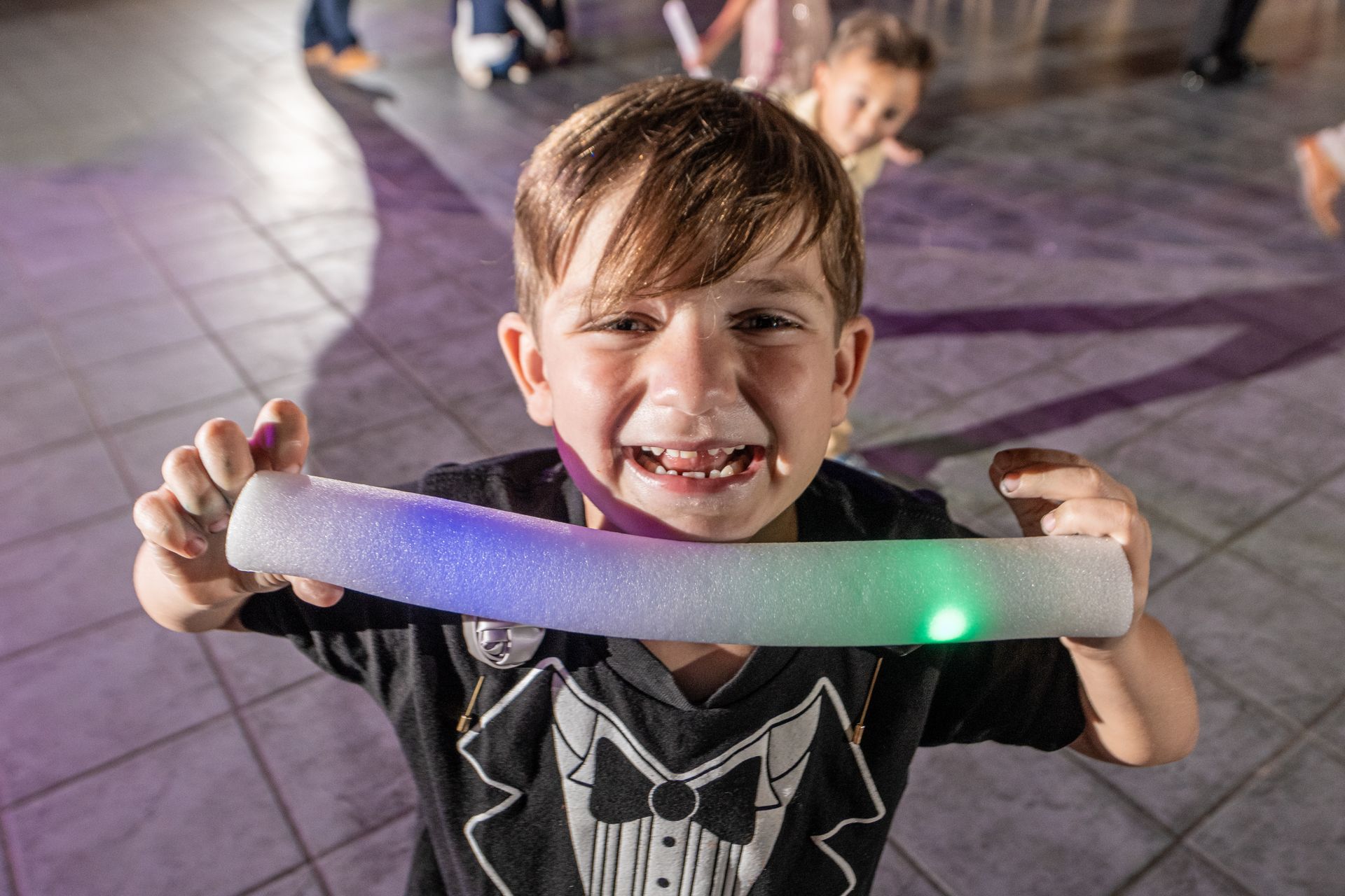 boy smiling with glow stick at party