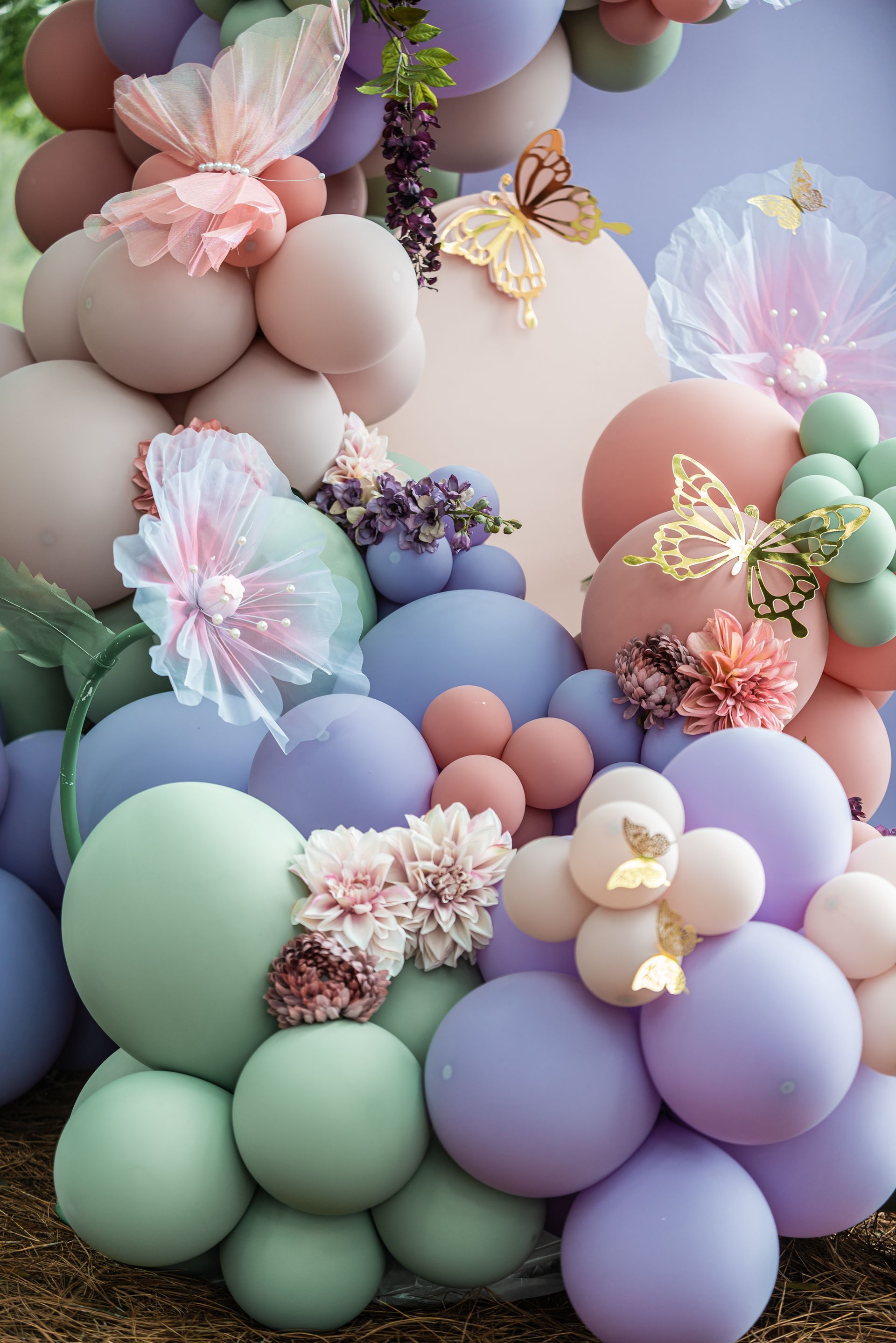 pastel balloon arch with butterflies and flowers