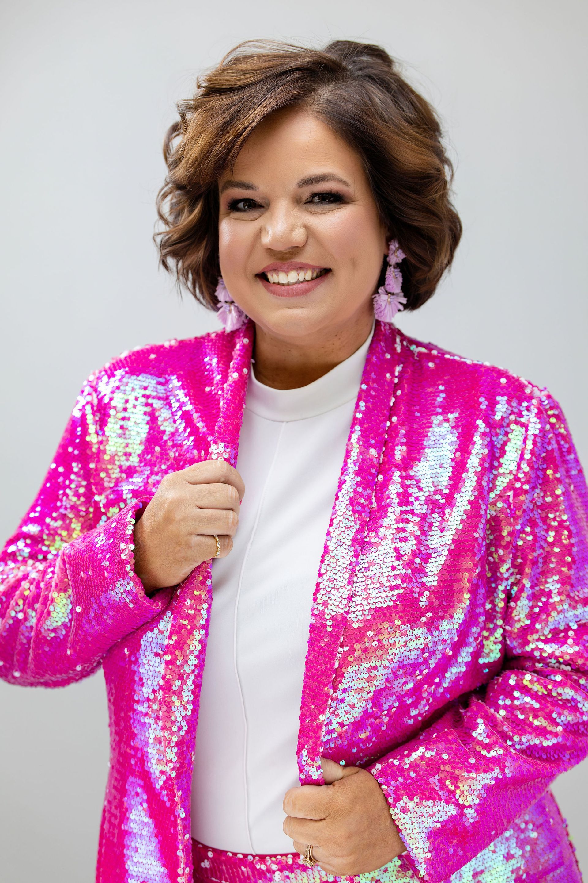 callie carr headshot wearing purple sequin blazer