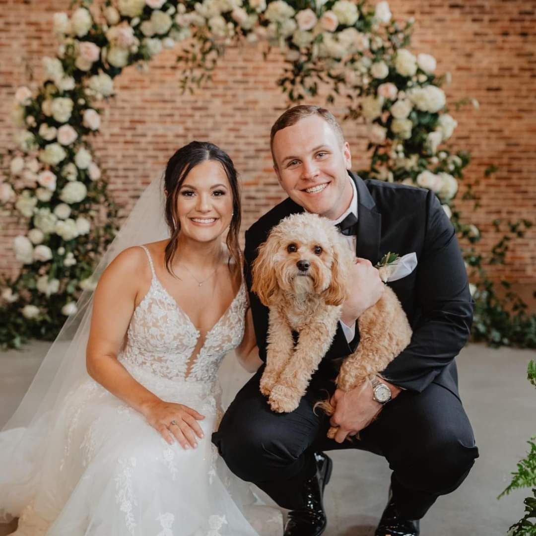 bride and groom posing with their dog