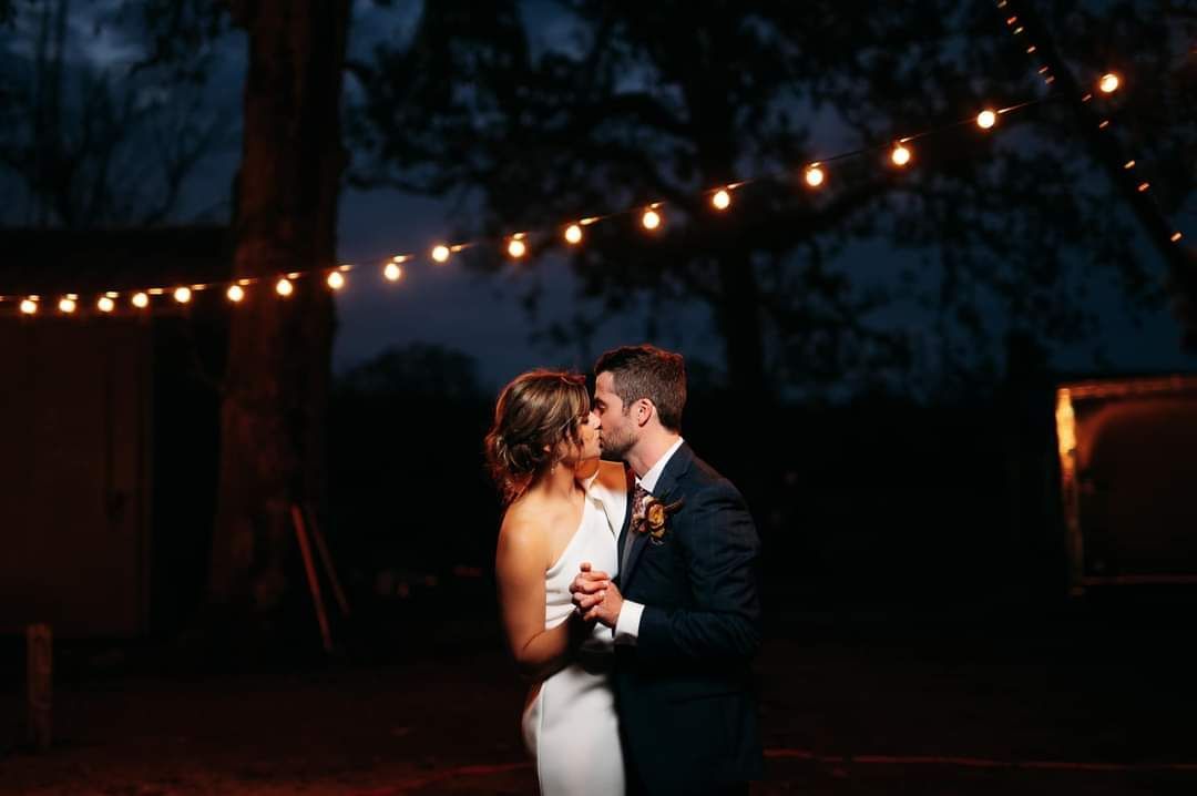 bride and groom's first dance under string lights