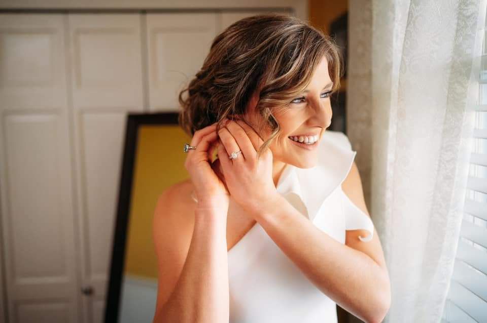bride putting on earrings