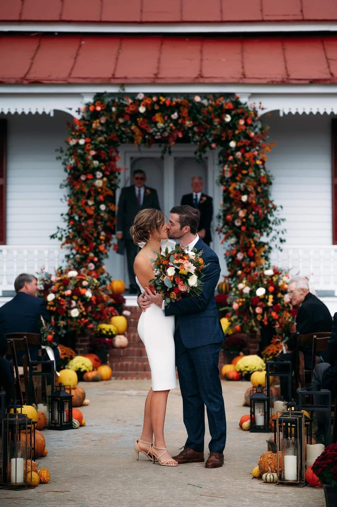 bride and groom kissing during fall outdoor wedding ceremony