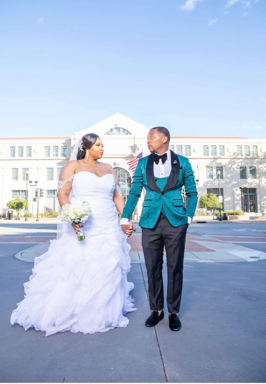 bride and groom holding hands in front of wedding venue
