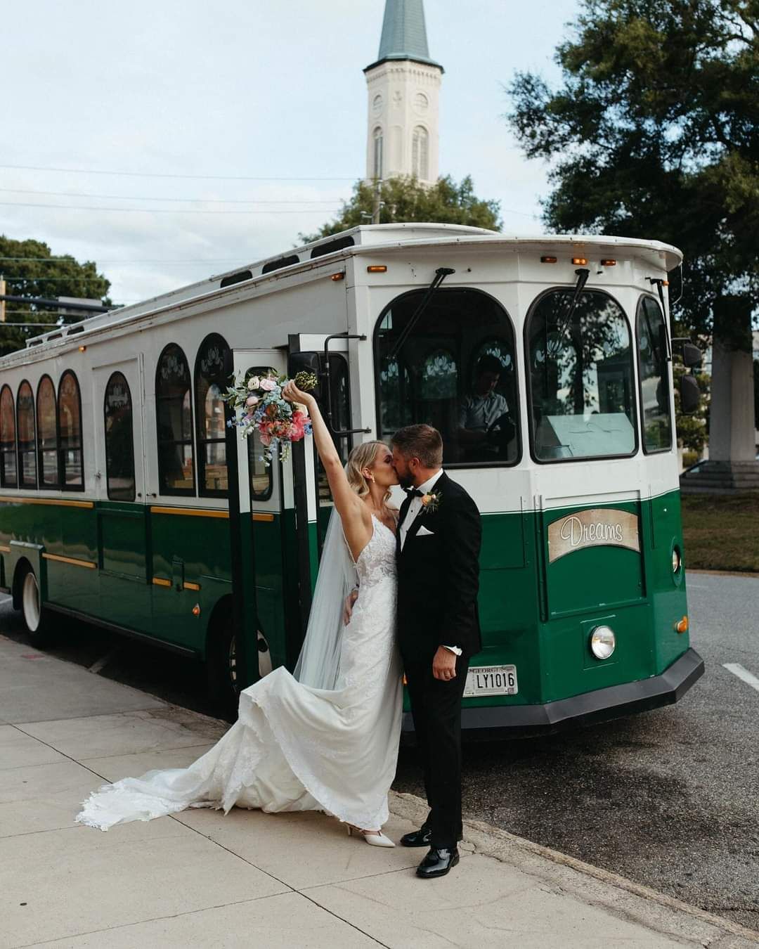 bride and groom in front of historic trolley