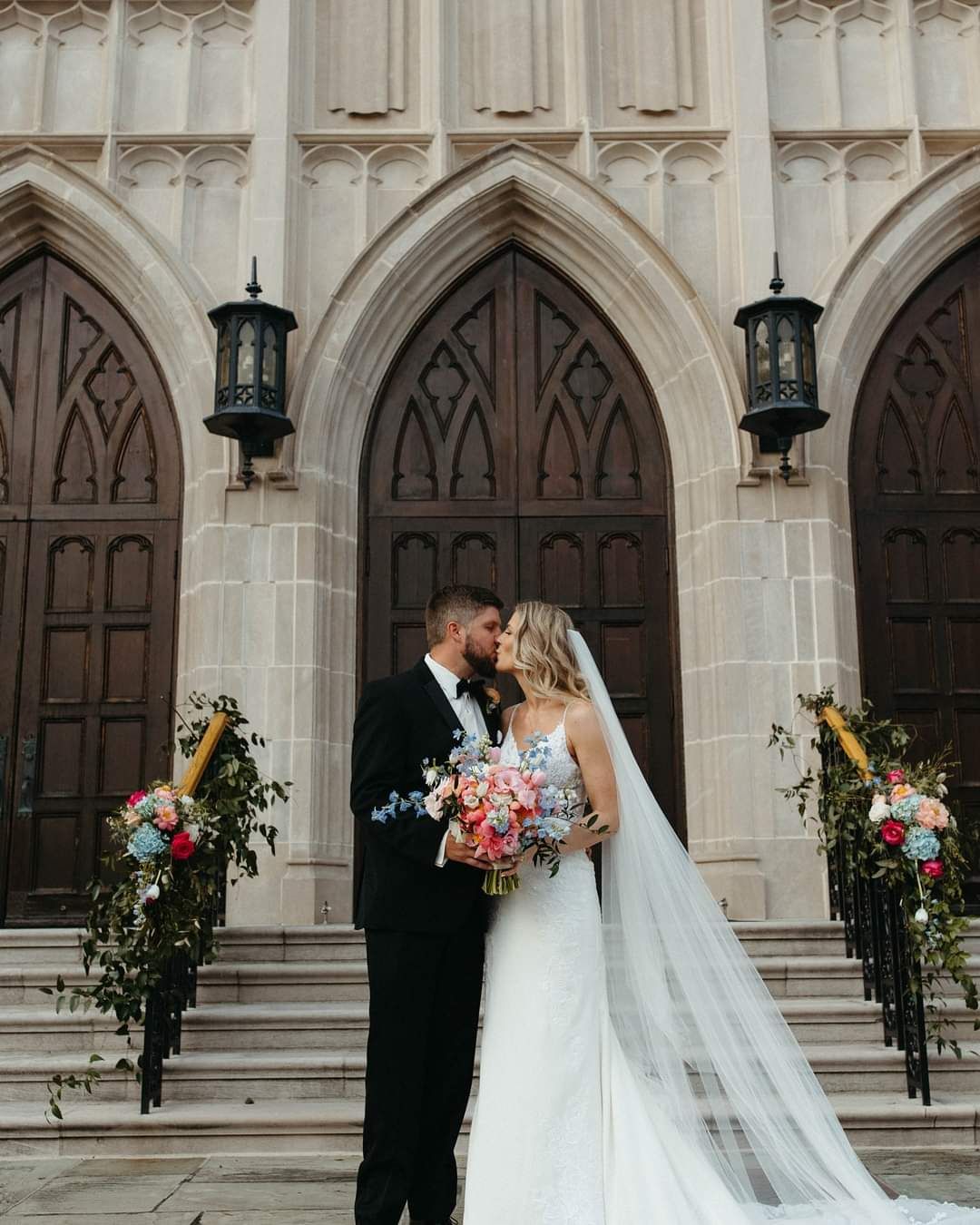 bride and groom kissing on historic church steps