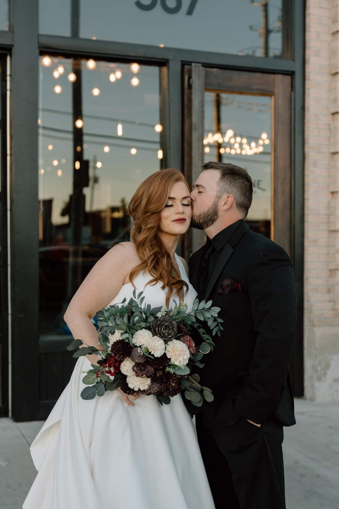 groom kissing bride on the forehead