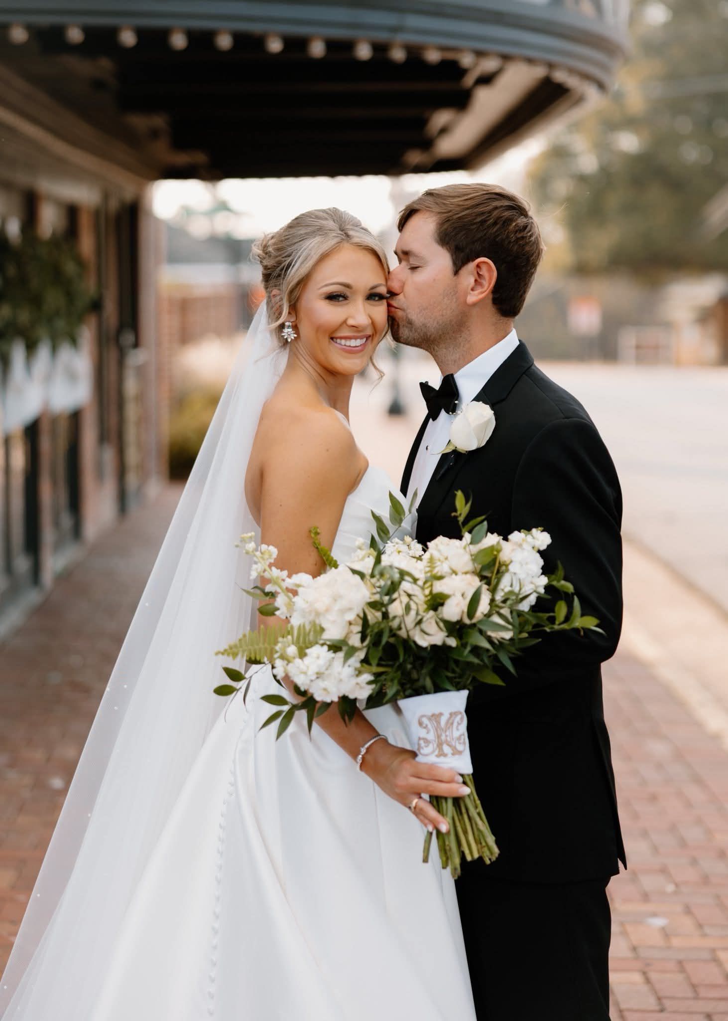 groom kissing bride on the forehead