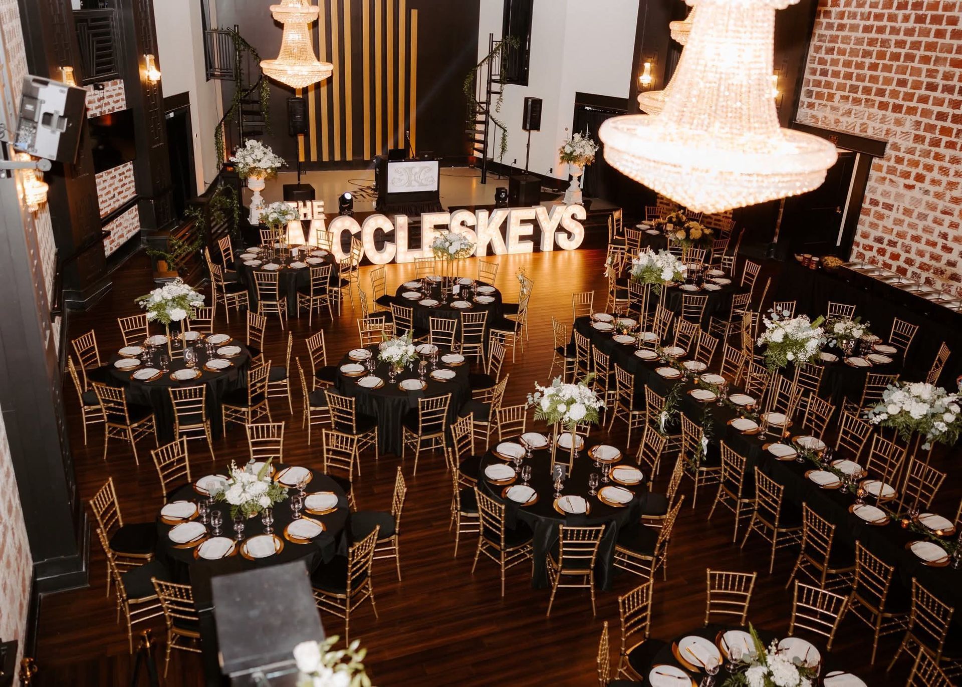 wedding reception with black and gold color scheme and large marquee lights of couple's name