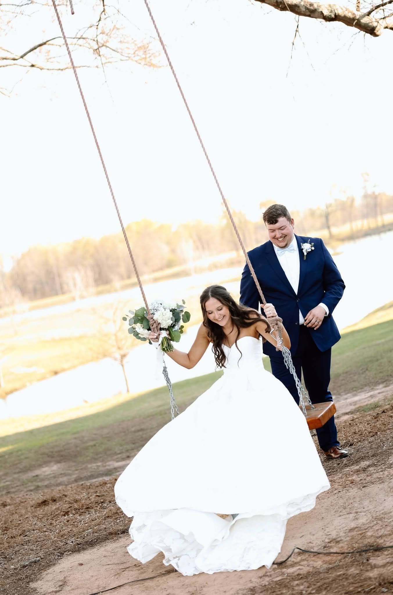 groom pushing bride on rope swing