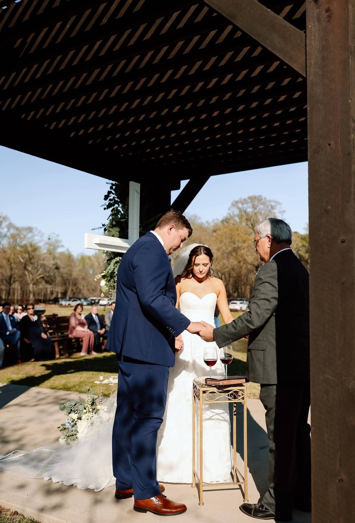 bride and groom praying with officiant