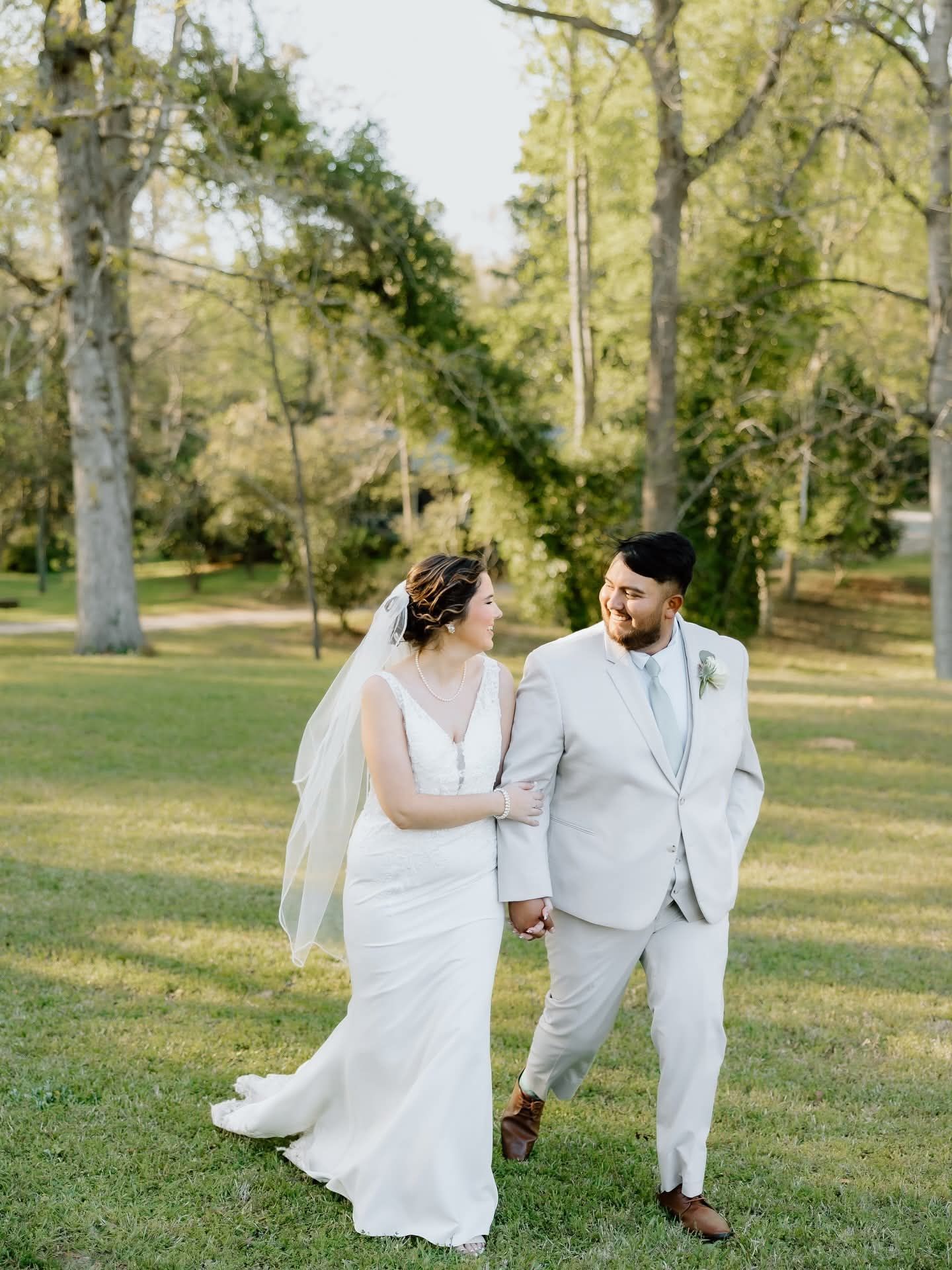 bride and groom walking through field