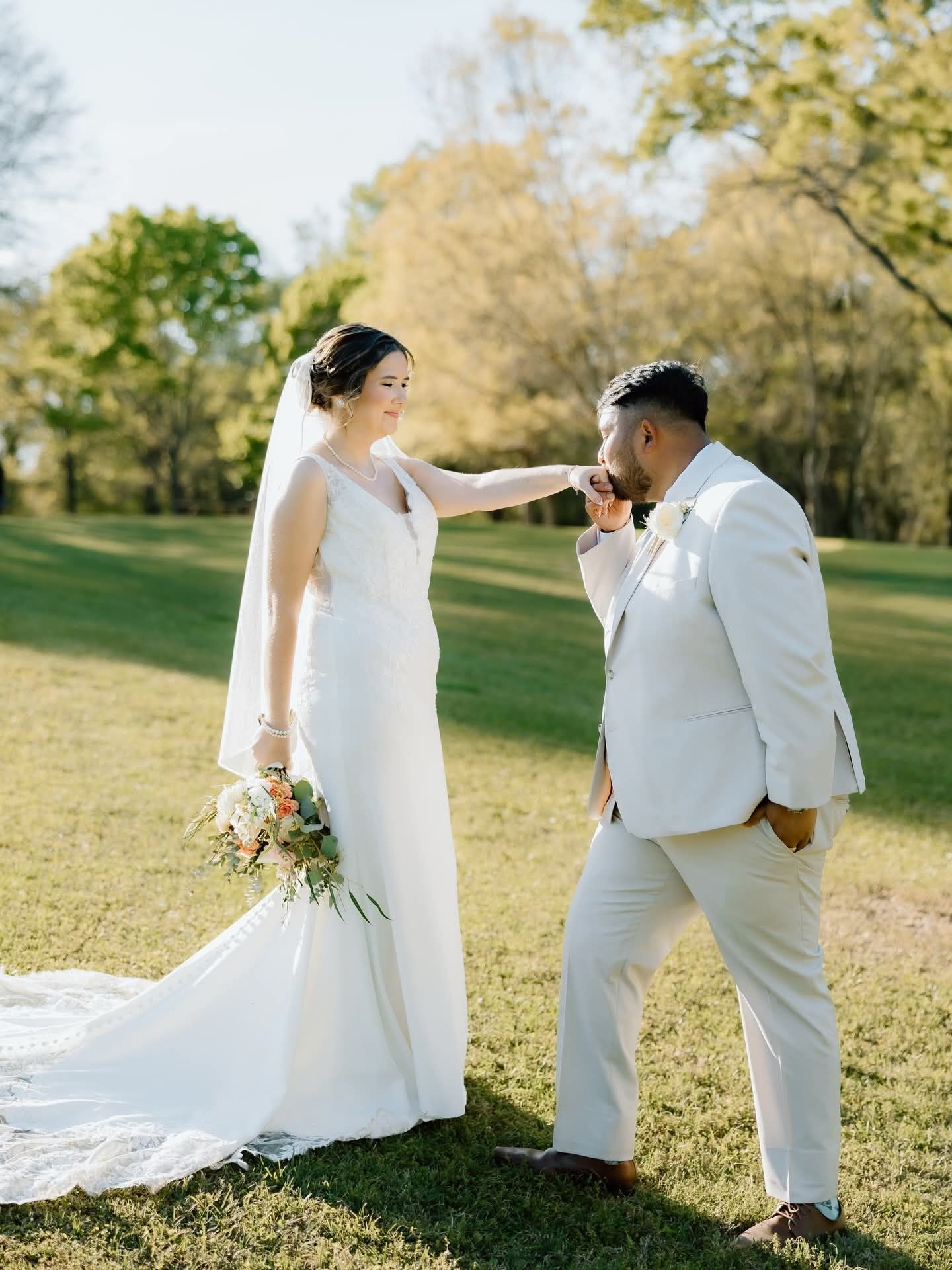 groom kissing bride's hand