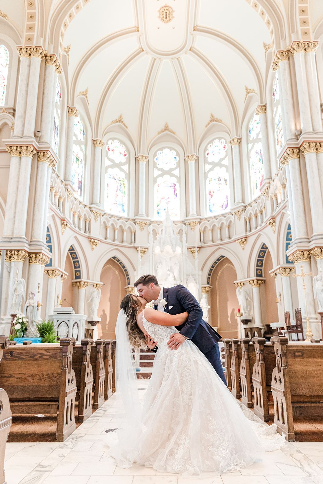 bride and groom kissing in large church