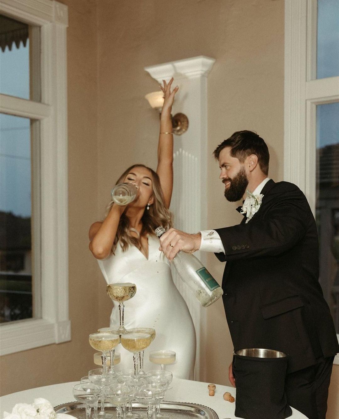 bride and groom drinking from champagne tower