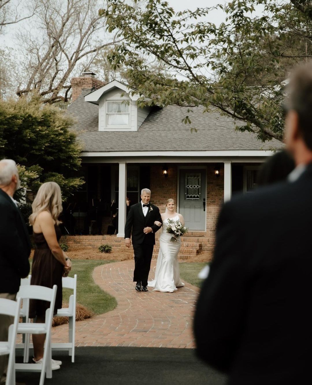 father walking bride down the aisle in outdoor wedding ceremony