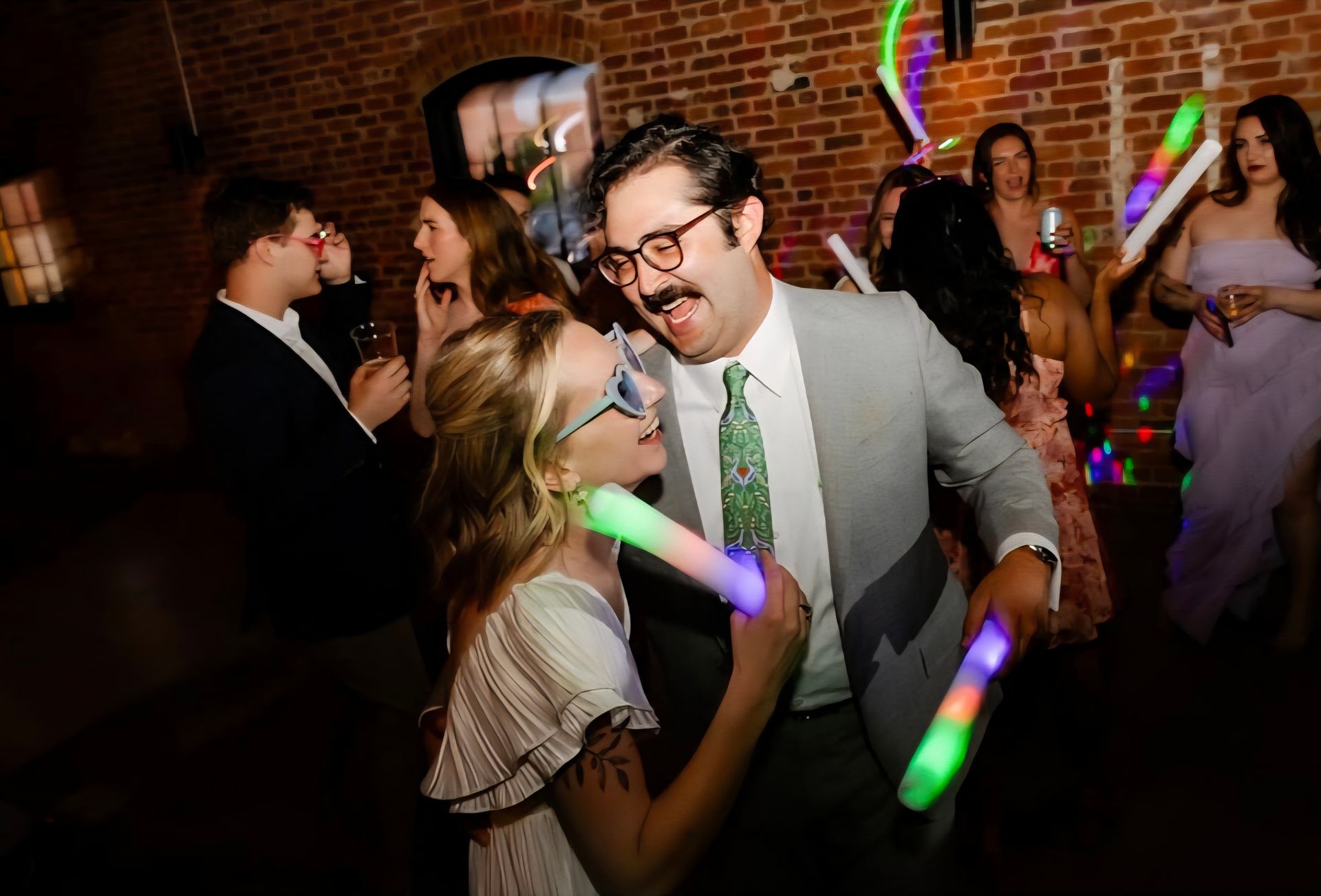 wedding guests dancing with glow sticks