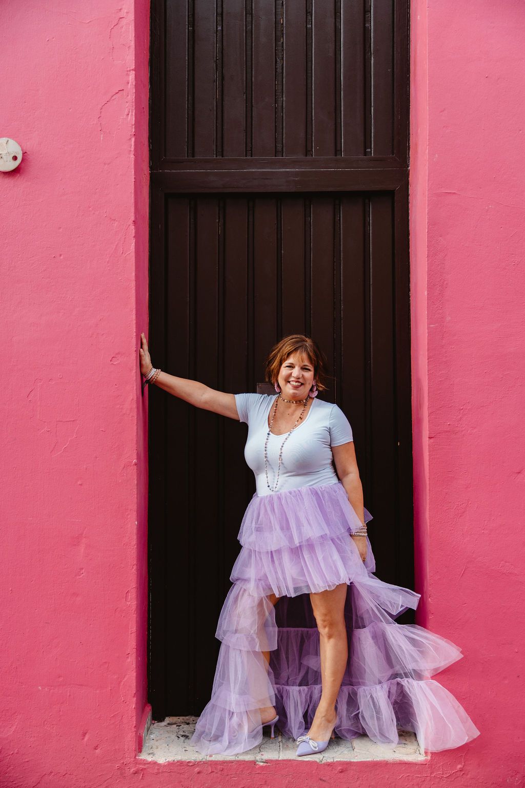 callie carr standing against pink wall in purple tulle skirt 