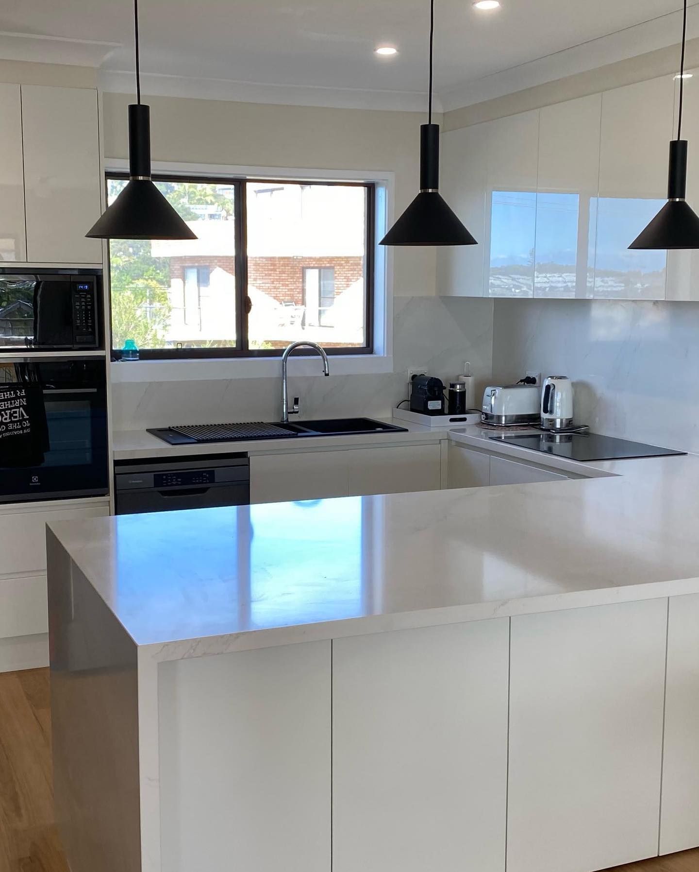 A Kitchen With White Cabinets, a Sink, a Stove, and a Window — Kenross Kitchens In Wyong, NSW