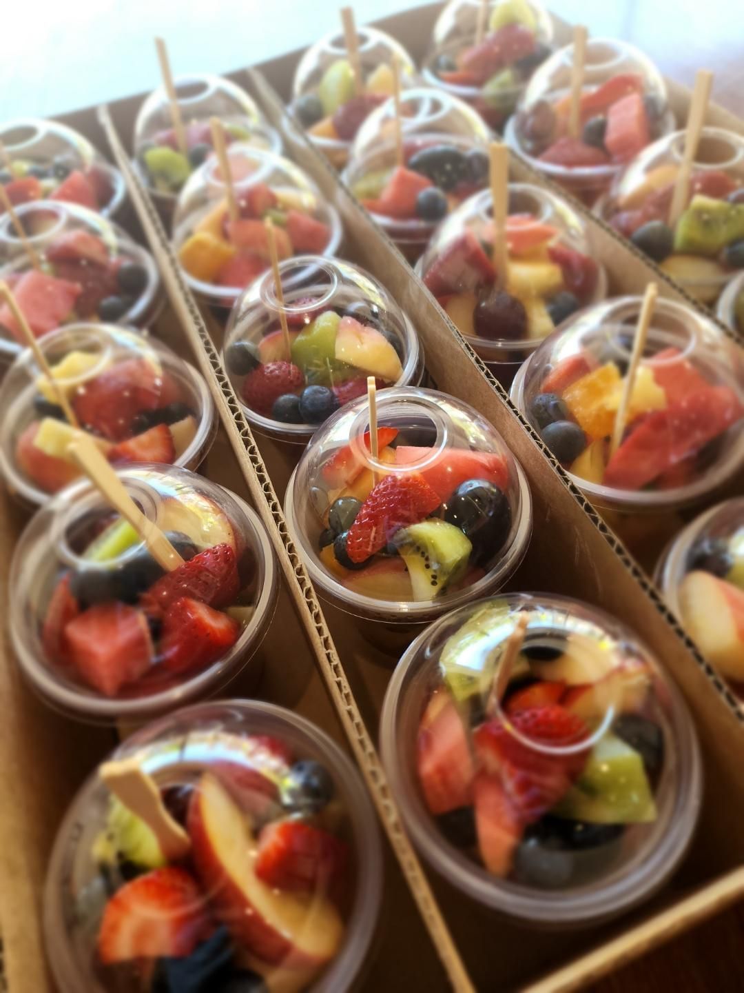 A Cardboard Box Filled With Plastic Cups Filled With Fruit — Geurie General Store In Geurie, NSW