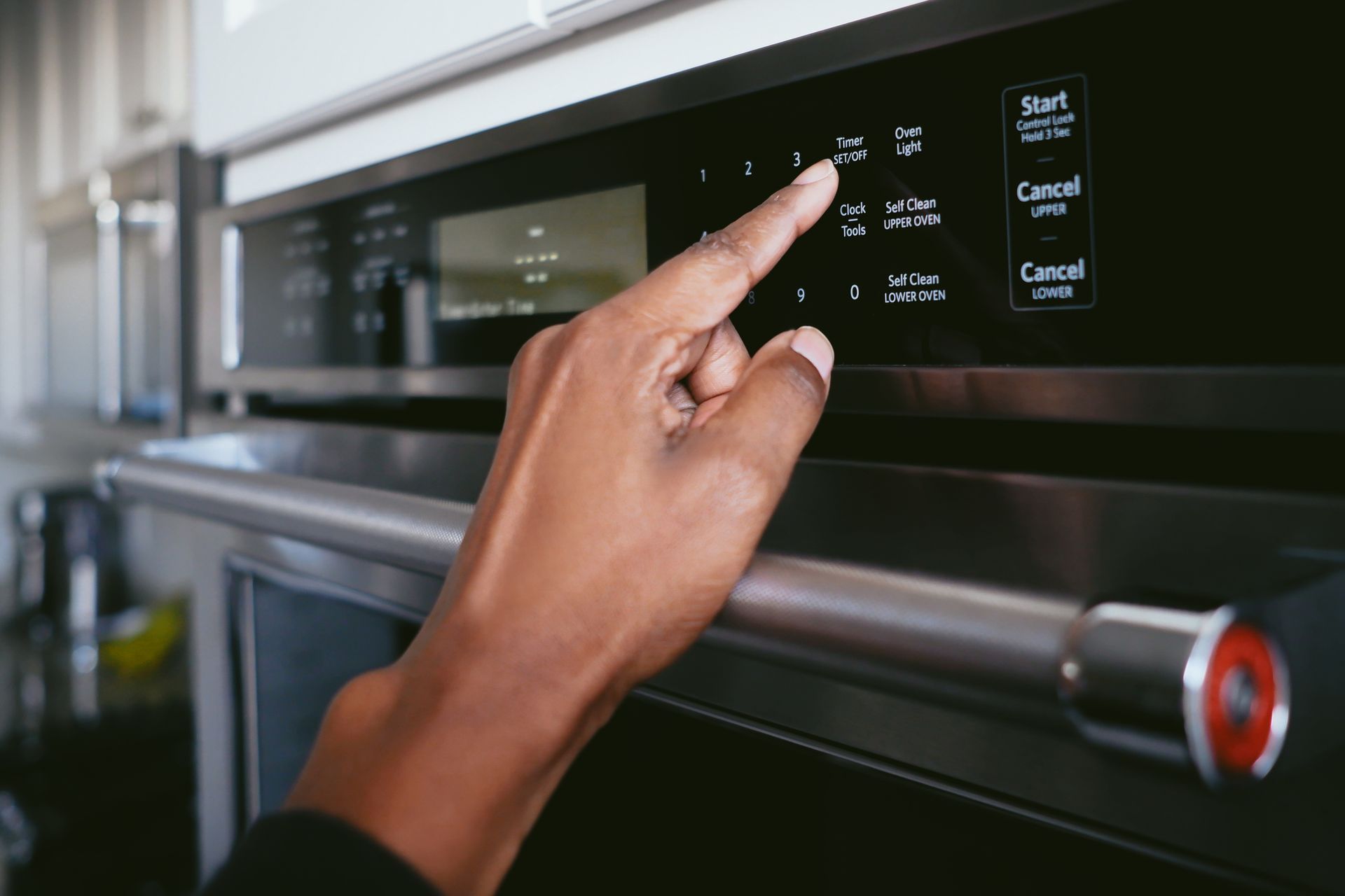 A Person is Pressing a Button on an Oven - Auckland, NZ - Stove Works Electrical
