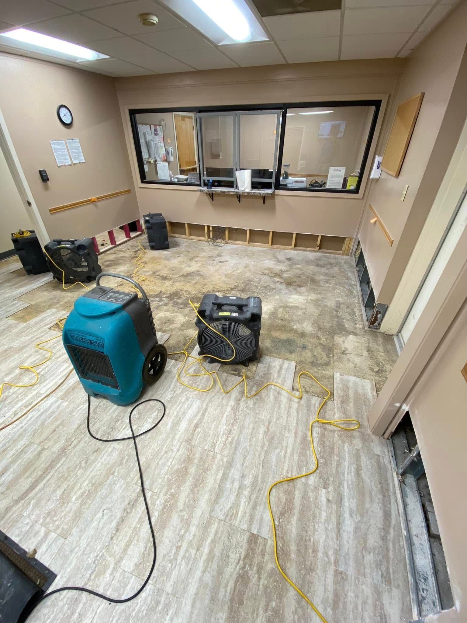 Office room under renovation with tools, cables, and a windowed counter area