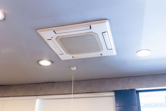 Ceiling cassette air conditioner with recessed lights and a window blind below