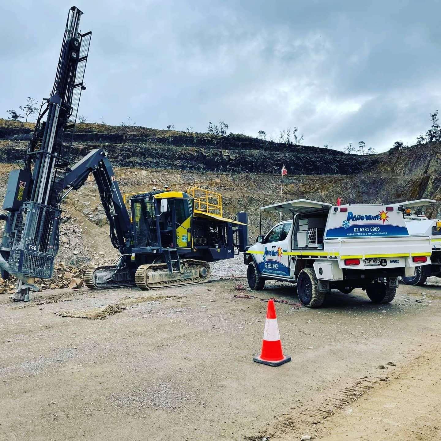 Mining Site With a Drill Rig, Truck, and Cone on a Dirt Road Against a Cloudy Sky — Auto Watt in Kelso, NSW