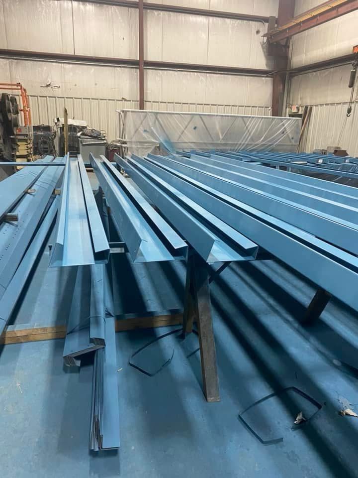 Blue metal beams stacked inside an industrial warehouse