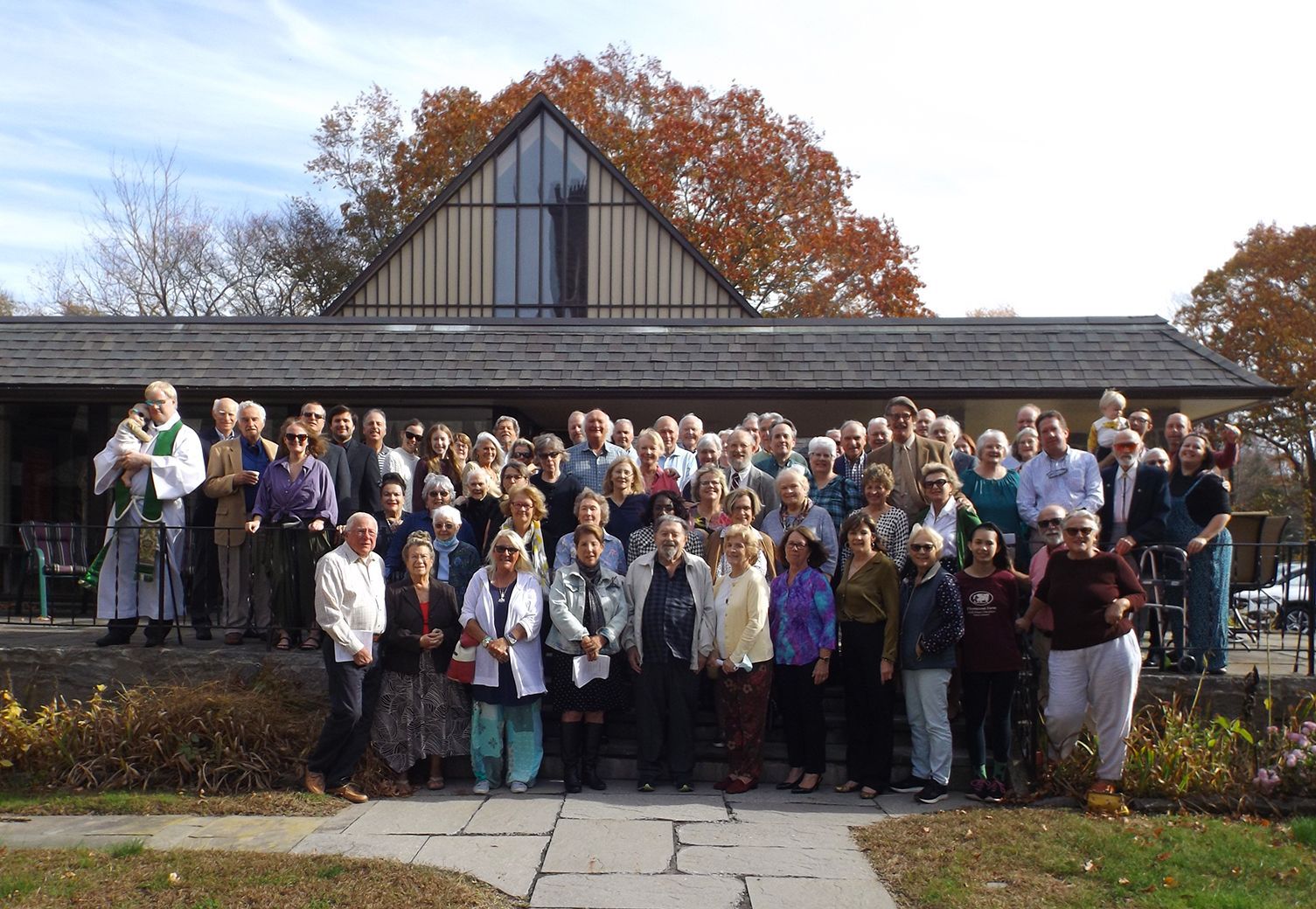 The Congregation poses together outdoors on Grace Church's stone patio steps in partial sunlight on All Saints Day 2022