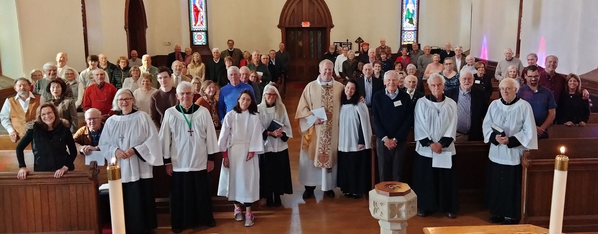 The Congregation poses inside of Grace Church's softly lit chapel on All Saints Day 2024