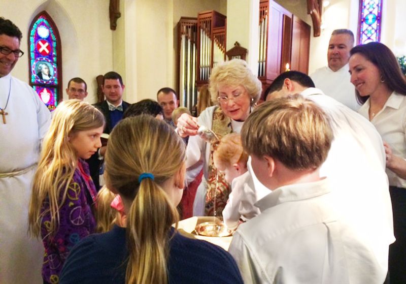 Pastor Ellendale Hoffman conducting a Child Baptism ceremony with surrounding family