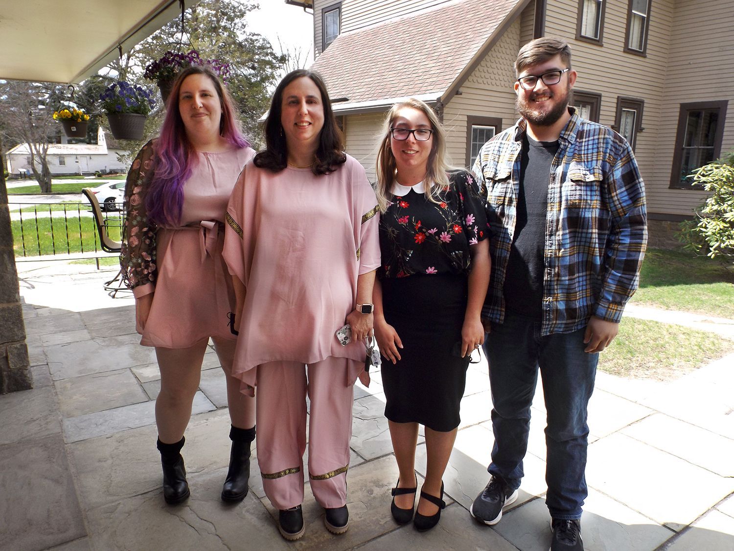 A family group stands outdoors on the church patio smiling
